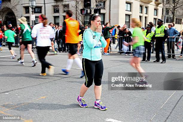 Emily Locher Weston, Connecticut looks out as runners pass near Kenmore Square after two bombs exploded during the 117th Boston Marathon on April 15,...