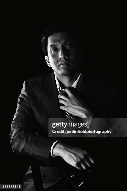 man in dark black and white in suit and tie - black white business poeple portraits dark stock-fotos und bilder