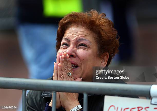 Woman kneels and prays at the scene of the first explosion on Boylston Street near the finish line of the 117th Boston Marathon on April 15, 2013.