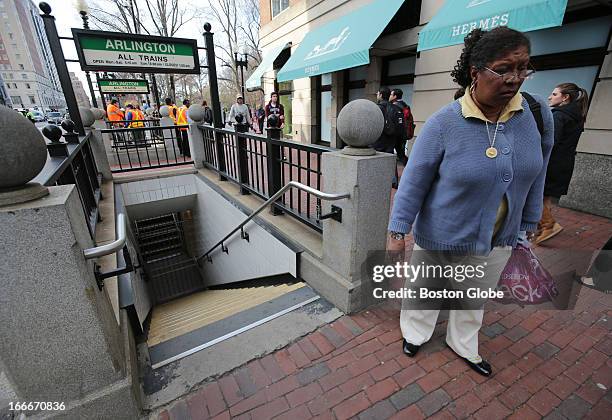 Woman turns away from the entrance of the Arlington T station at the intersection of Arlington and Boylston, where service was suspended after two...