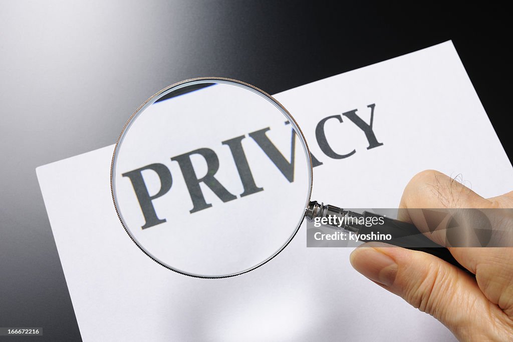 Holding a magnifying glass, looking for privacy