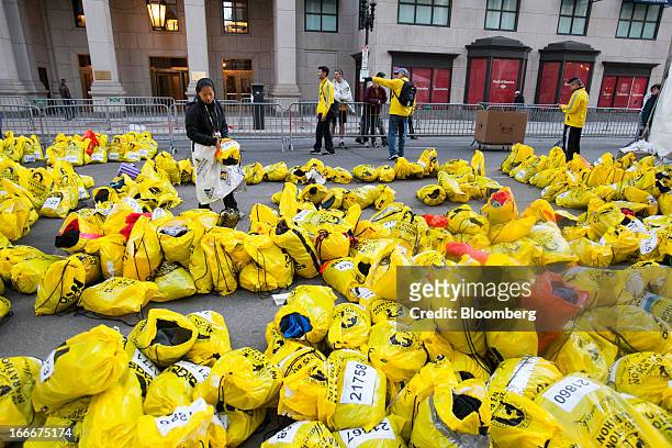 Volunteer sorts through unclaimed runners' bags after two explosions occurred along the final stretch of the Boston Marathon on Boylston Street in...