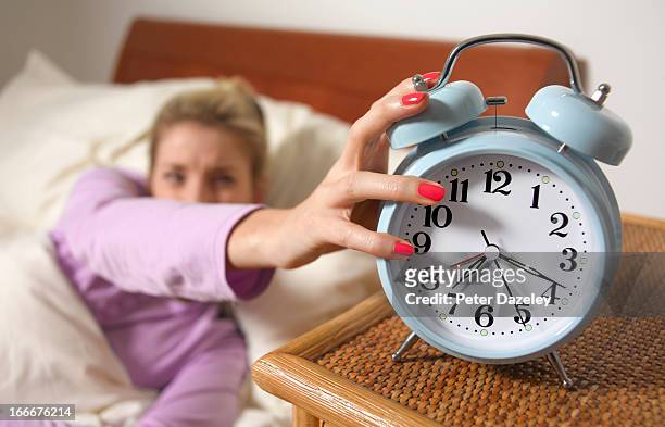 young woman turning off alarm - alarm clock close up stock pictures, royalty-free photos & images