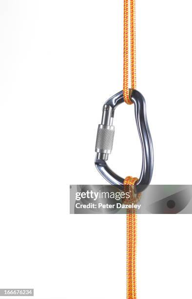 orange climbing rope connected by karabiner - artículo de montañismo fotografías e imágenes de stock