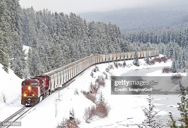 treno rossa accelerazione attraverso montagne rocciose - locomotive foto e immagini stock