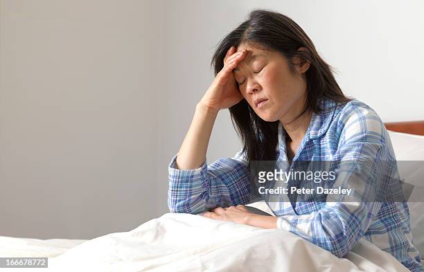 woman with head ache in bed - felver stock pictures, royalty-free photos & images