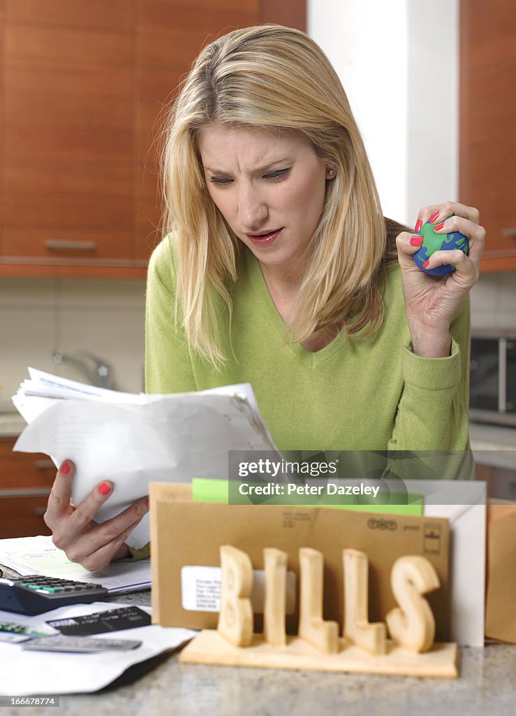 Woman checking bills with stress ball
