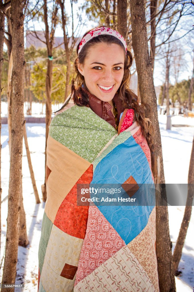 Portrait of a young girl wrapped in a quilt