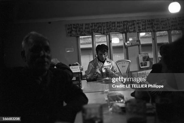 Johnny Hallyday In Czechoslovakia. En Tchécoslovaquie, le 3 juillet 1966, Johnny HALLYDAY, avec une casquette, au comptoir d'un bar, lors de sa...