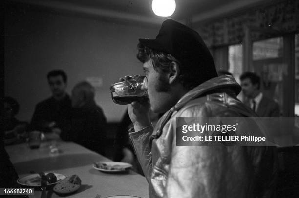 Johnny Hallyday In Czechoslovakia. En Tchécoslovaquie, le 3 juillet 1966, Johnny HALLYDAY, avec une casquette, au comptoir d'un bar, boit une bière,...