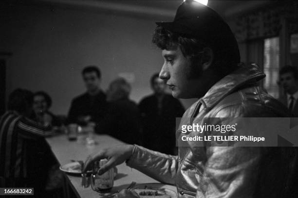 Johnny Hallyday In Czechoslovakia. En Tchécoslovaquie, le 3 juillet 1966, Johnny HALLYDAY, avec une casquette, au comptoir d'un bar, avec une bière,...