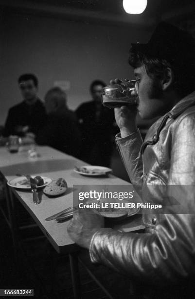 Johnny Hallyday In Czechoslovakia. En Tchécoslovaquie, le 3 juillet 1966, Johnny HALLYDAY, avec une casquette, au comptoir d'un bar, boit une bière,...