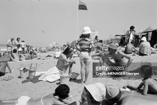 Biarritz. Biarritz- 23 Août 1961- Loisirs: sur la plage, vacanciers en maillot de bains se prélassant, hormis une jeune femme en chemisier et jupe...