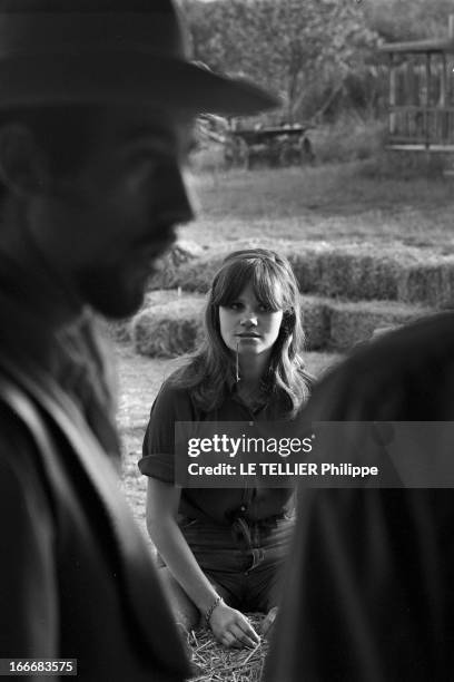 Ranches For Tourism And Recreation In France. En France, le 20 juin 1966, portrait d'une jeune femme avec une brindille d'herbe à la bouche, avec un...