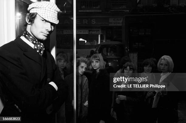 Winter 1965 Men Fashion In London. En Grande-Bretagne, à Londres, dans un magasin de mode du quartier de Carnaby, un jeune homme qui fait des...