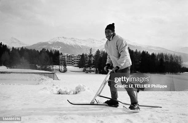 The Snow Bicycle. En Suisse, à Crans-Montana, 17 février 1967, sur une piste de ski, l'acteur Lino VENTURA debout sur un ski-bob, riant. Il porte un...