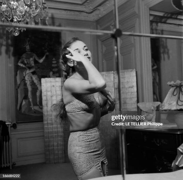 Lingerie In 1956. En 1956, une jeune femme se coiffant, vue dans un miroir, porte un ensemble de sous vêtements avec une culotte haute, et un soutien...