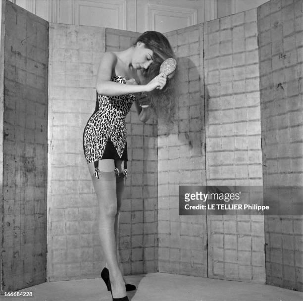 Lingerie In 1956. En 1956, une jeune femme se brossant les cheveux devant un paravent, porte un sous vêtement bustier en tissu imitant la peau de...
