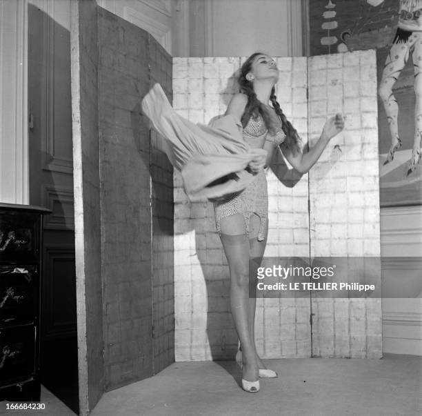 Lingerie In 1956. En 1956, une jeune femme coiffée de nattes, se déshabille devant un paravent. Sous sa jupe elle porte un ensemble de sous vêtements...