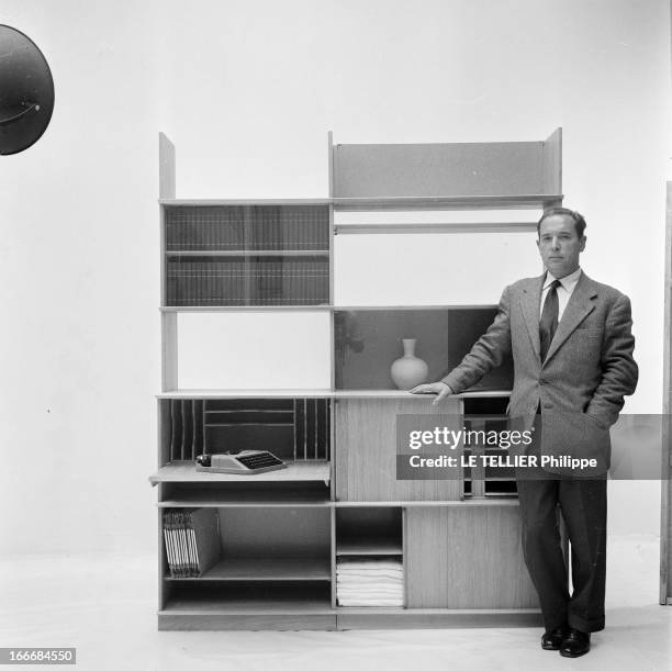 Ancient And Modern Furniture In The Fifties. En 1955, en studio sur fond neutre, un homme présente un ensemble de mobilier pour la maison, aux lignes...