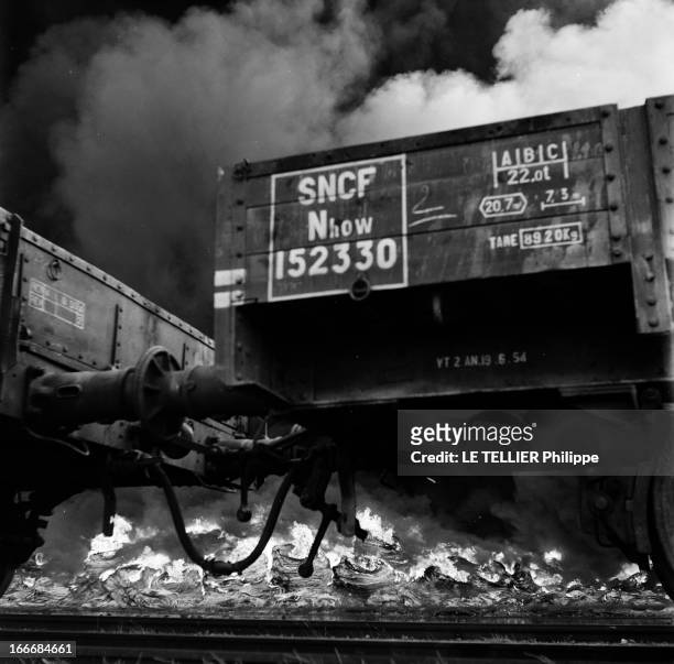 Fire Of A Tire Depot. France, juillet 1955, un dépôt de pneus est incendié près d'une voie de chemin de fer de la SNCF. Des wagons sont encore...
