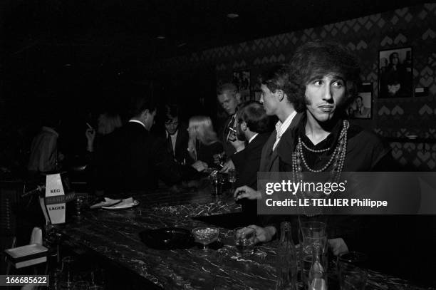 Jane Birkin And John Crittle In London. Angleterre, Londres, 28 septembre 1967, un mannequin habillé à la mode hippie au comptoir d'un bar, devant un...