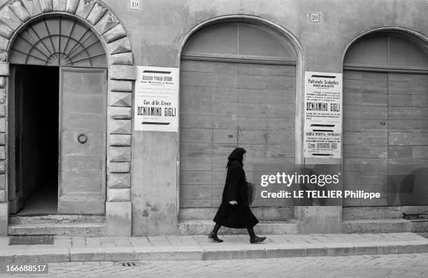 The Villa Of Beniamino Gigli Near Recanati. En Italie, à Recanati - 26 décembre 1957 - Une femme en noir coiffée d'un foulard marchant devant une...