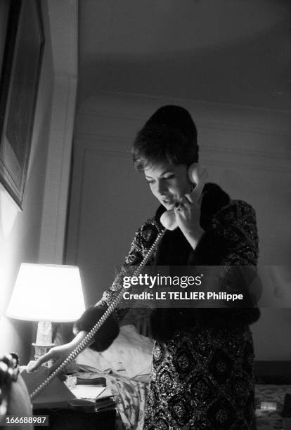 Rendezvous With Gina Lollobrigida And Jean-Paul Belmondo. Le 4 janvier 1963, Gina Lollobrigida, au téléphone, debout dans sa chambre d'hôtel.