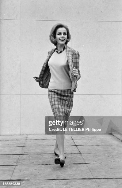 Presentation Of Women Fashion In 1963. En janvier 1963, en extérieur, une jeune femme blonde, présente un modèle de tailleur, jupe et vestes à...