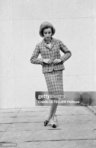 Presentation Of Women Fashion In 1963. En janvier 1963, en extérieur, une jeune femme blonde, présente un modèle de tailleur, jupe et vestes à...