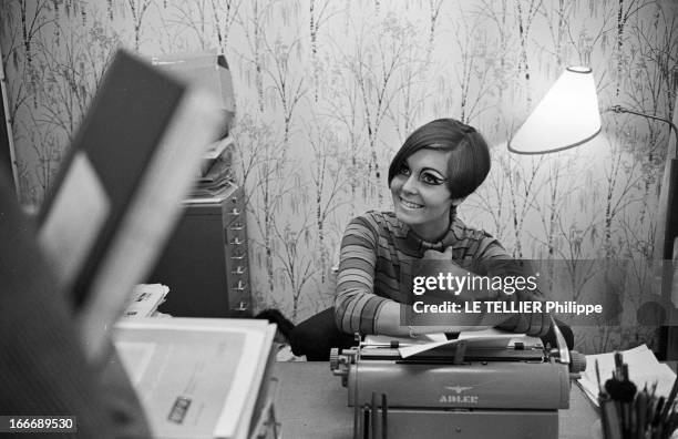 Op Art Make-Up In London. A Londres, Kari-Ann, secrétaire, assise à son bureau, les yeux entourés d'un maquillage 'Op Art' et portant une robe col...