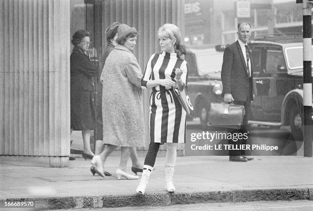 Op Art Make-Up In London. A Londres, dans la rue, le modèle Eve, les yeux entourés d'un maquillage 'Op Art', portant une robe des collants et un sac...