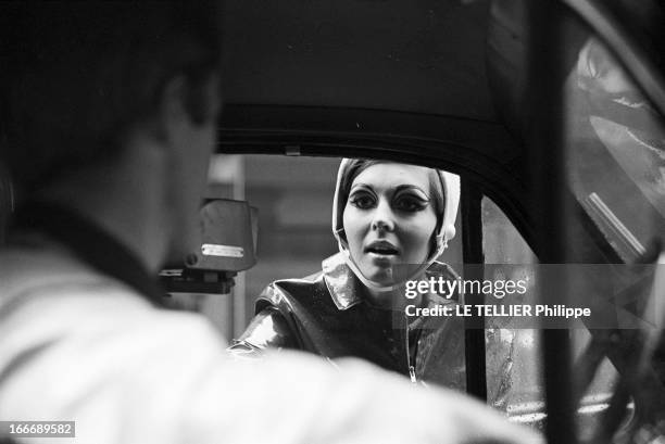 Op Art Make-Up In London. A Londres, dans la rue, le modèle Kari-Ann, les yeux entourés d'un maquillage 'Op Art' portant un imperméable ciré sur une...