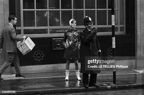 Op Art Make-Up In London. A Londres, dans la rue, le modèle Kari-Ann, les yeux entourés d'un maquillage 'Op Art' portant un imperméable ciré sur une...