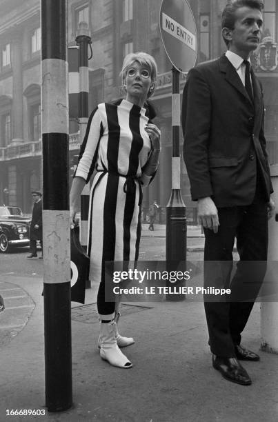 Op Art Make-Up In London. A Londres, dans la rue, le modèle Eve, les yeux entourés d'un maquillage 'Op Art', portant une robe des collants et un sac...