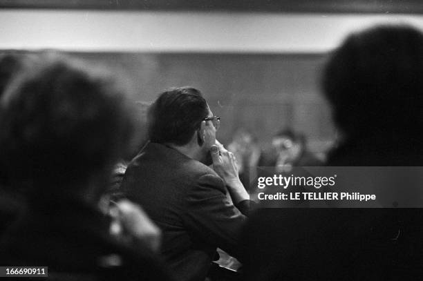 The Anonymous Alcoholics. Le 23 avril 1964, portrait d'un homme assis, vu de dos, une cigarette à la main, lors d'une réunion des 'alcooliques...