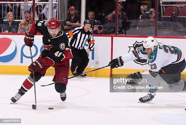 Alex Bolduc of the Phoenix Coyotes skates with the puck past Scott Gomez of the San Jose Sharks during the second period of the NHL game at...