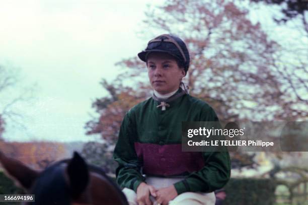 Female Jockeys. Femme jockey montée sur un cheval portant casque verte et mauve ses lunettes posées sur sa toque verte.