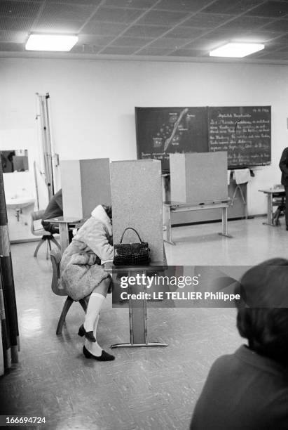 Federal Election Of 1966 In Bavaria. Le 24 novembre 1966, en République fédérale d'Allemagne, un bureau de vote dans une école : une femme avec un...