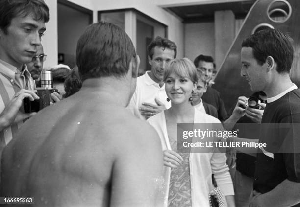 Swimmer Francis Luyce. En juillet 1967, le nageur français Fancis LUYCE, torse nu, de dos, face à une femme souriante non identifiée, lors de son...