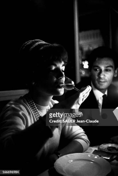 Shooting Of The Film 'Le Proces' By Orson Welles. Plan de trois-quarts de Romy SCHNEIDER à table, un collier de perles autour du cou et un chapeau...