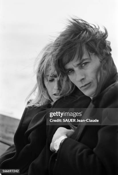 Rendezvous With Alain Delon And Nathalie. Attitude de Nathalie DELON regardant un oiseau caché sous le caban de son mari Alain DELON sur la dune du...