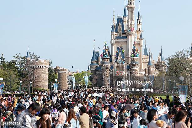 Visitors walk past the Cinderella Castle during 30th anniversary celebrations of Tokyo Disneyland, operated by Oriental Land Co., at the amusement...