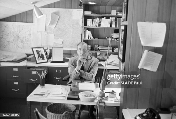 Rendezvous With Cornelius Ryan. Etats-Unis -22 mai 1964- Chez lui, Cornelius RYAN, ses lunettes de vue dans une main, assis à son bureau; plan de...