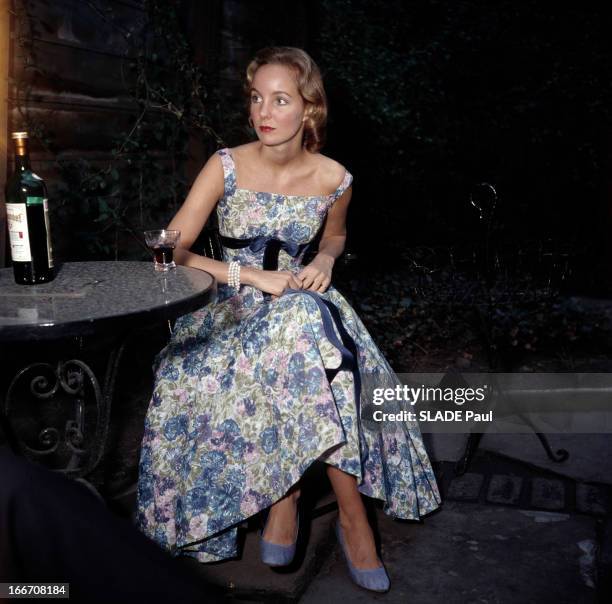Daphn, An American At The Ball Beginners. Au Bal des débutantes, DAPHNE, américaine, portant une robe, posant à une table, buvant un verre de vin.