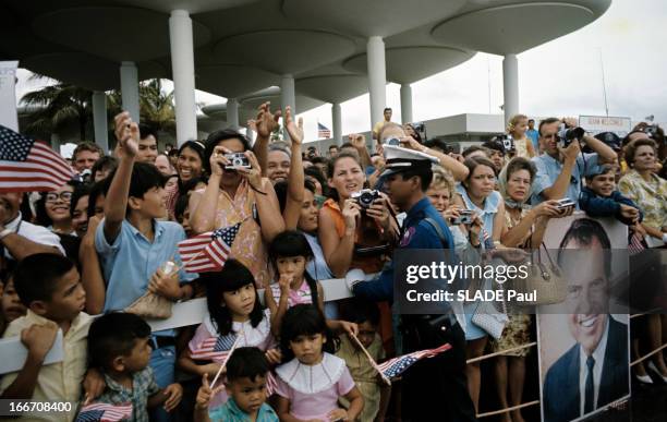 Official Visit Of President Richard Nixon To The Island Of Guam In The Pacific. A l'île de Guam, des habitants massés sous un préau, tenant des...