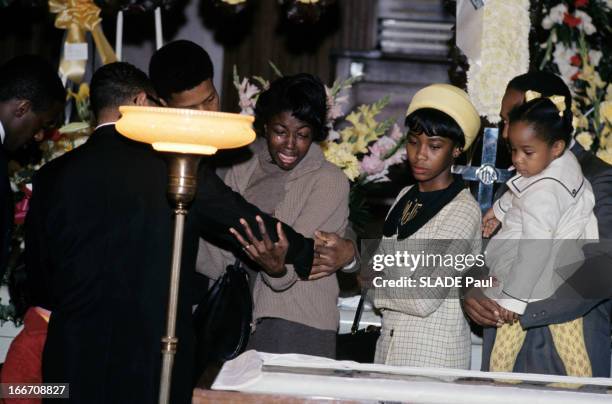 Death And Funeral Of Martin Luther King. A Atlanta, dans une salle décorée de fleurs, une femme noire en pleurs, retenue par un homme et deux autres...