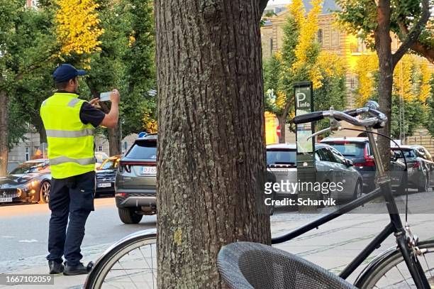 car parking attendant photographs illegally parked car in frederiksberg, copenhagen - law problems stock pictures, royalty-free photos & images