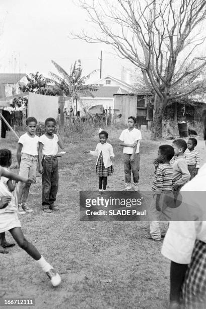 Ruby Bridges, 6 years old, wearing white cardigan and hair bow, plays with friends, New Orleans, US, December 1960. Original caption reads: 'Aux...