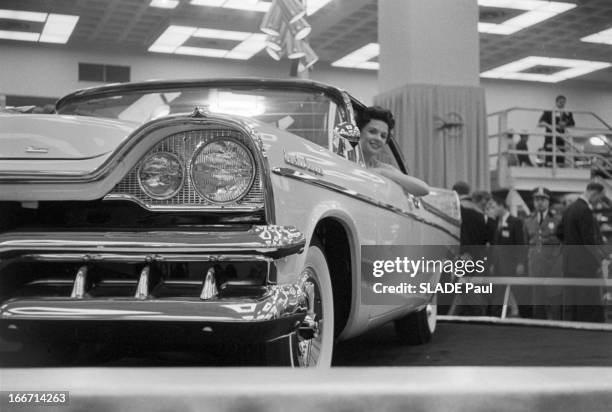 Motor Show 1956 In New York. A New York, en 1956, vue avant en contre plongée d'une femme au volant d'une voiture Dodge Custom Royal exposée au Salon...